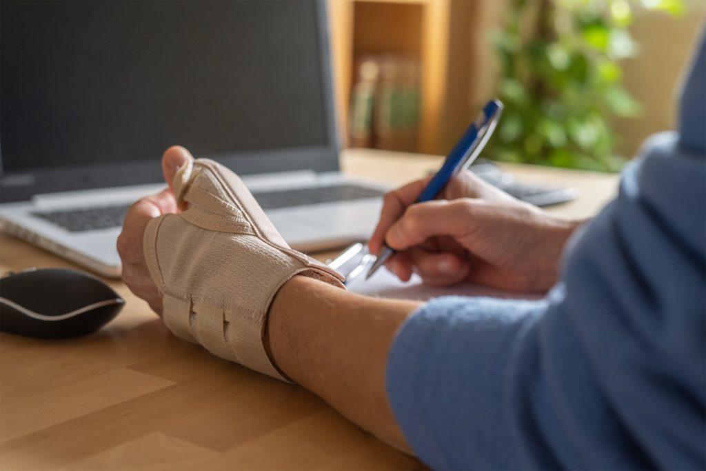 Person trägt eine Schütze für das Handgelenk beim Arbeiten