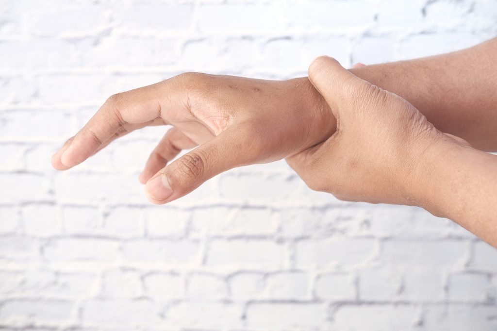 Mann hält sein Handgelenk